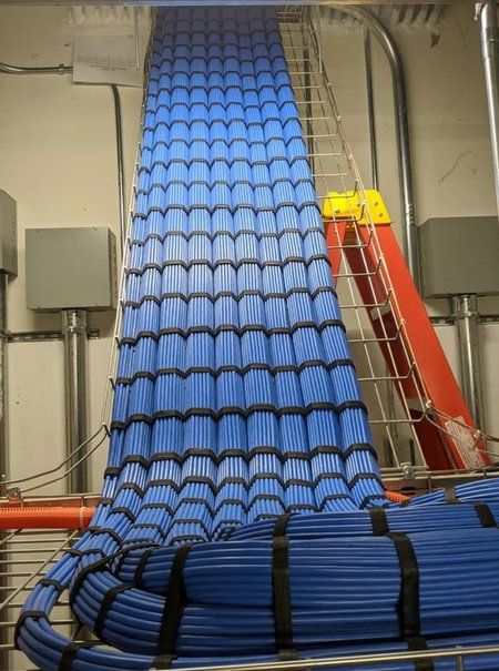Large blue cable bundle descending in a uniform waterfall